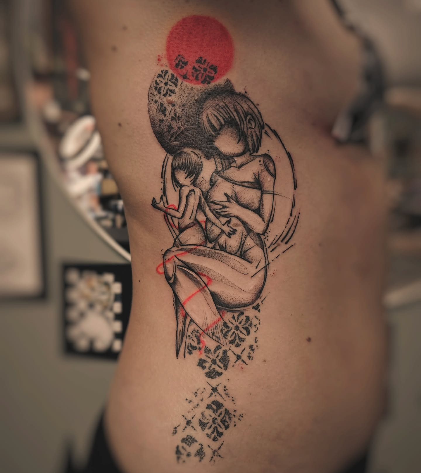 Humanism tattoo of mother and child with red sun